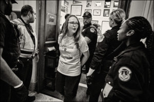 ADAPTer getting arrested and escorted out of an office by Capitol police officers.