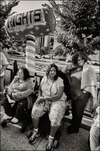 Three ADAPTers sitting outside with a blow up hammer saying “Rights”.