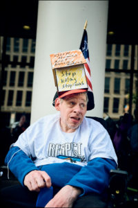 ADAPTer in wheelchair wearing a house shaped cardboard hat.