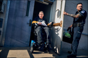 Capitol police officer holding door for ADAPTer exiting the Capitol police station.