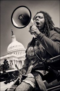 ADAPTer in wheelchair yelling into megaphone in front of the Capitol.
